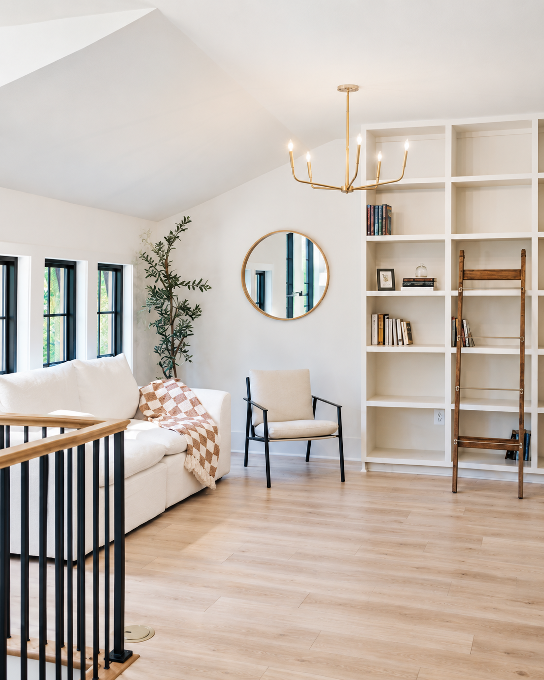 The library: floor-to-ceiling white shelving with a rolling oak ladder