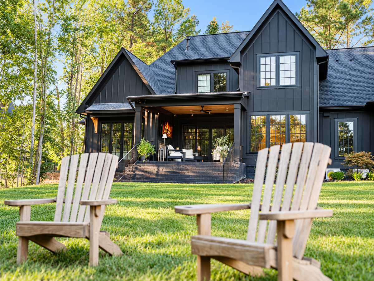 The back of the house: covered porch, lawn and two Adirondack chairs